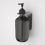 Caroma Liano II gunmetal soap bottle holder, wall-mounted with bottle dispenser on a bracket