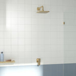 Caroma Luna II brushed brass wall-mounted bath and shower mixer in a tiled bathroom shower setting