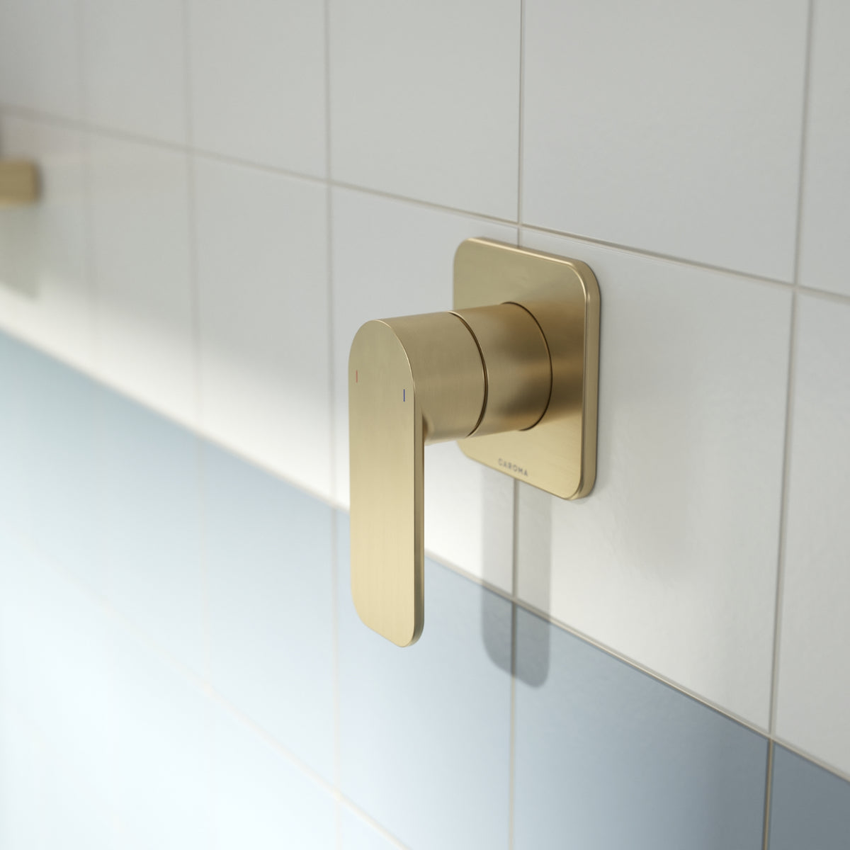 Caroma Luna II wall-mounted bath/shower mixer in brushed brass with single lever on white tiled wall
