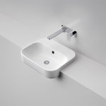 Caroma Luna semi recessed white ceramic basin with chrome wall tap, rectangular rounded design on a vanity bench