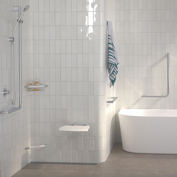 Caroma Opal white folding shower seat mounted in tiled shower, shown folded down beside a bath and grab rails