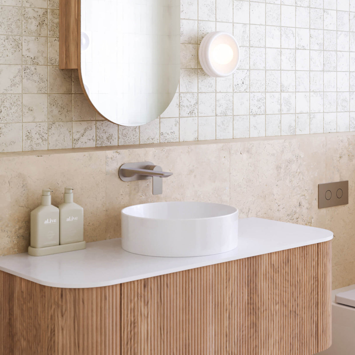 Caroma Urbane II chrome wall basin mixer above a round white basin in a modern bathroom vanity scene