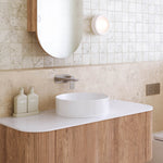 Caroma Urbane II wall basin/bath mixer in brushed nickel over a white round basin, shown in a bathroom vanity setting