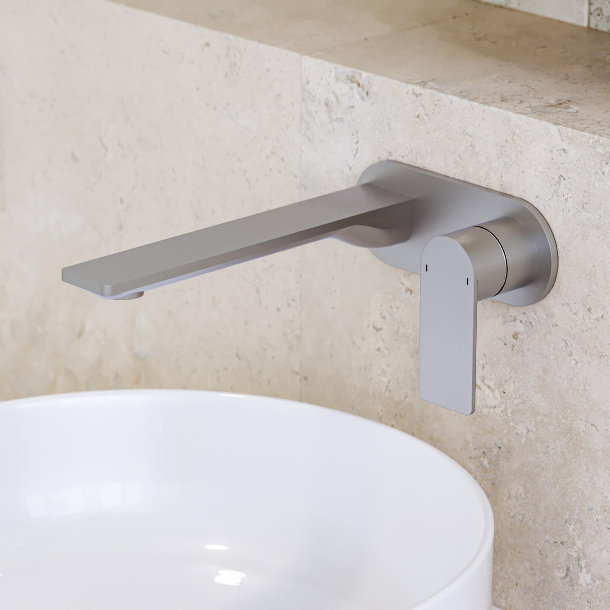 Caroma Urbane II wall-mounted basin mixer in brushed nickel with round spout, shown over a white vessel basin.