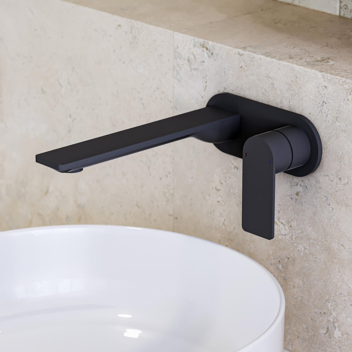 Caroma Urbane II wall-mounted basin mixer in matte black, shown over a white basin against stone tiles
