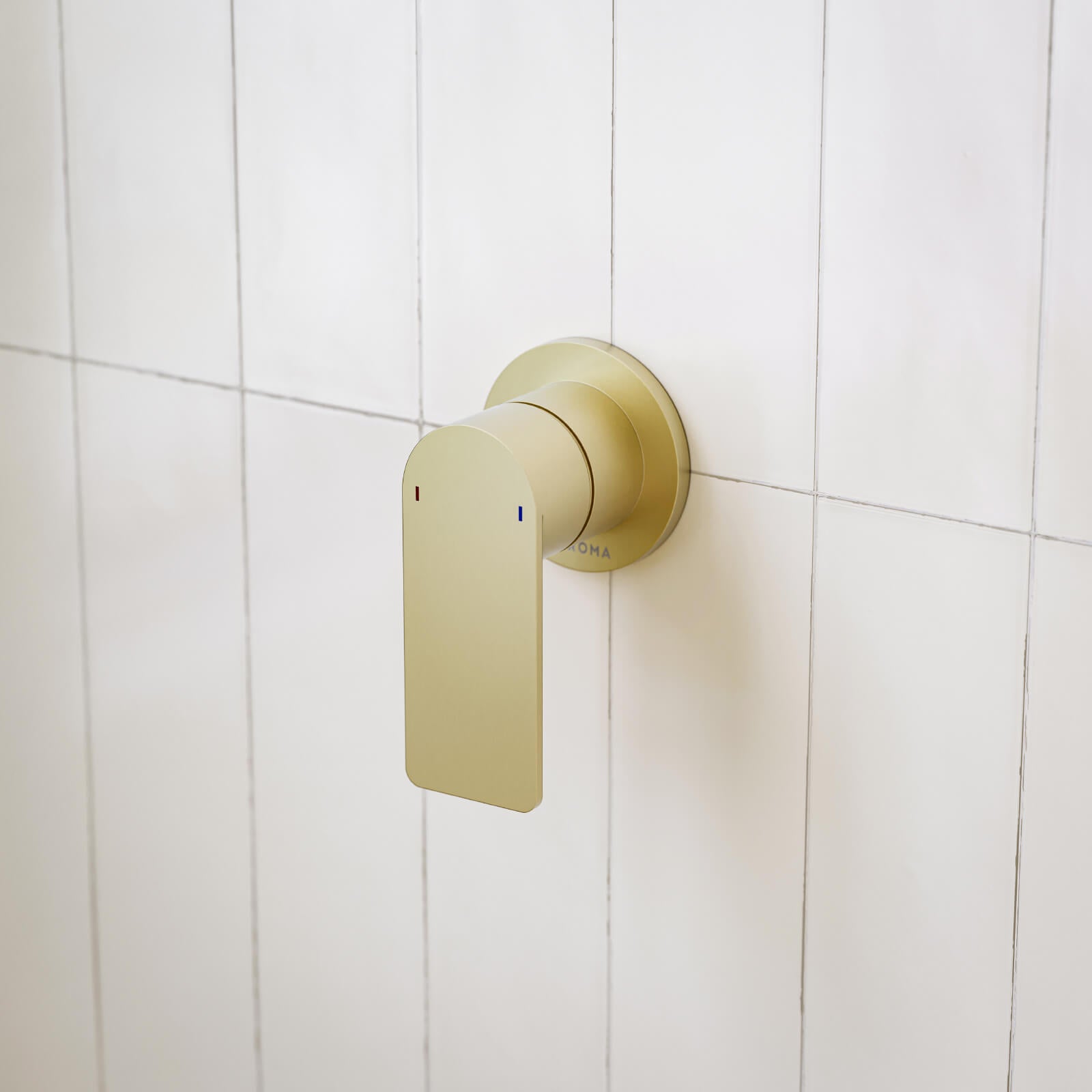 Caroma Urbane II round bath/shower mixer in brushed brass, wall-mounted on white tiles