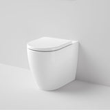 Caroma Urbane II white wall-faced toilet pan with soft close seat, shown front angle in a minimalist bathroom setting