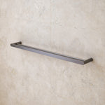 Caroma Urbane II double towel rail in gunmetal, mounted on a tiled bathroom wall