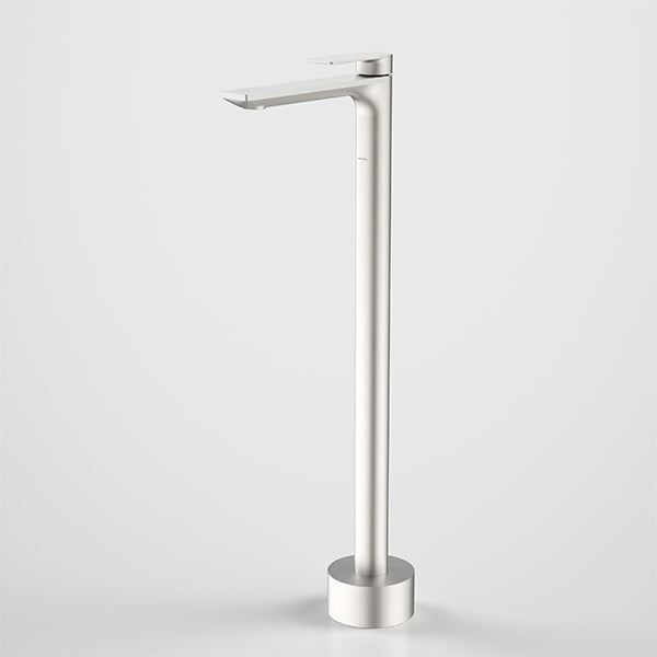 Caroma Urbane II floor-mounted bath filler in brushed nickel, tall modern tap with rectangular spout on round base, side view