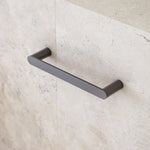 Caroma Urbane II gunmetal hand towel rail, wall-mounted in a modern bathroom, straight rectangular bar finish