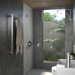 Caroma Urbane II vertical heated towel rail in polished stainless steel, shown installed in a modern bathroom with towel hanging on it