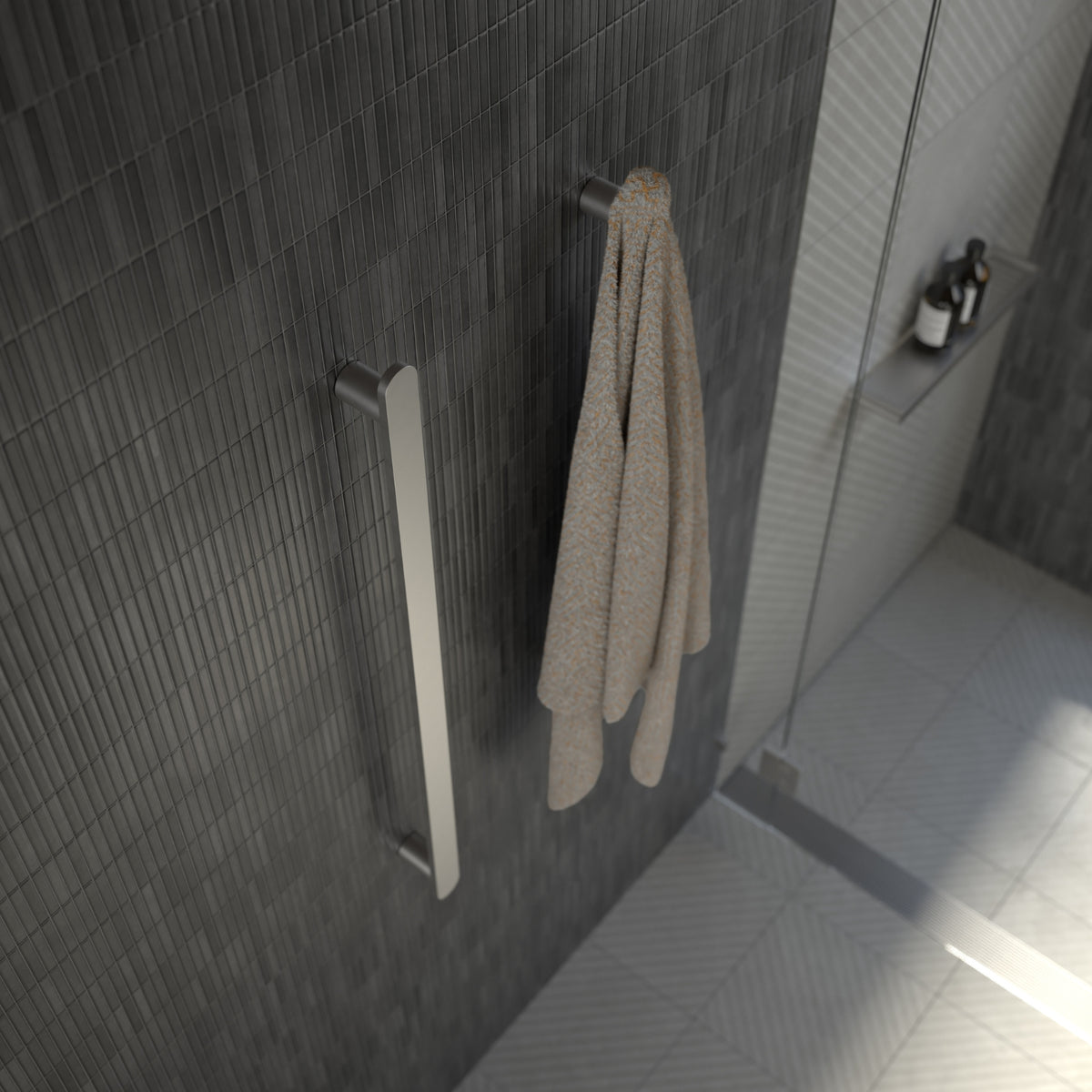 Caroma Urbane II vertical heated towel rail in polished stainless steel, shown mounted on a dark tiled bathroom wall with towel.