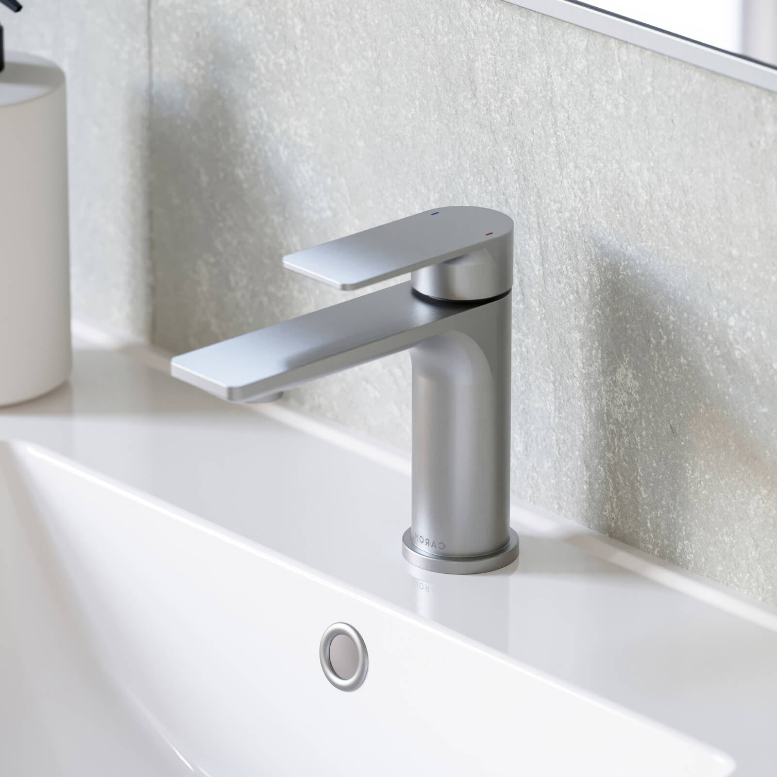 Caroma Urbane II brushed nickel basin mixer with slim modern handle over a white bathroom basin