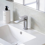 Caroma Urbane II chrome basin mixer on a white bathroom vanity sink, shown in a modern bathroom setting