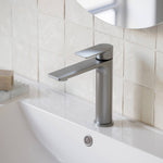 Caroma Urbane II mid tower basin mixer in brushed nickel, hob mounted on a white bathroom basin.