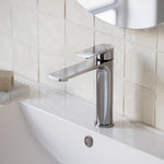 Caroma Urbane II chrome mid tower basin mixer on a bathroom vanity, shown in a close-up lifestyle setting
