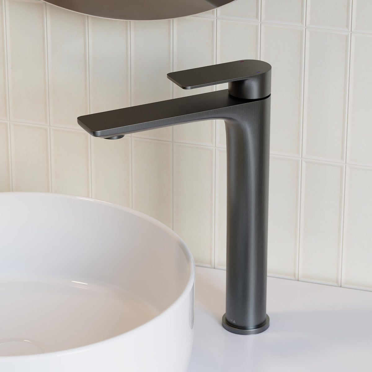 Caroma Urbane II tower basin mixer in gunmetal, shown with a white above-counter basin on a tiled bathroom vanity.