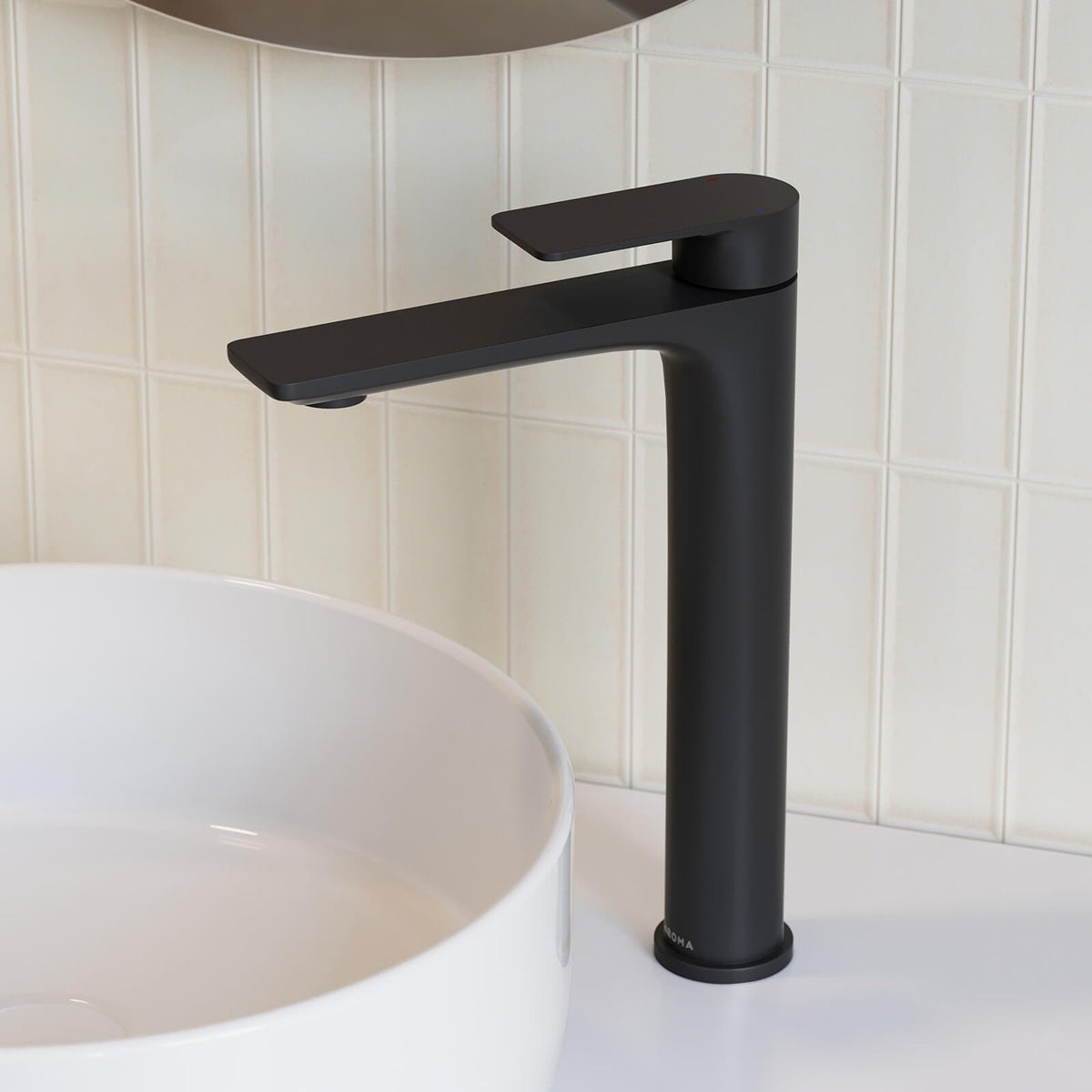 Caroma Urbane II tower basin mixer in matte black, shown beside a white vessel basin on a bathroom vanity