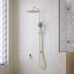 Caroma Urbane II twin rail shower in brushed brass, with round overhead rain shower and handset on a wall-mounted rail