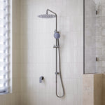 Caroma Urbane II twin rail shower in gunmetal, with round overhead drencher and hand shower in a tiled bathroom