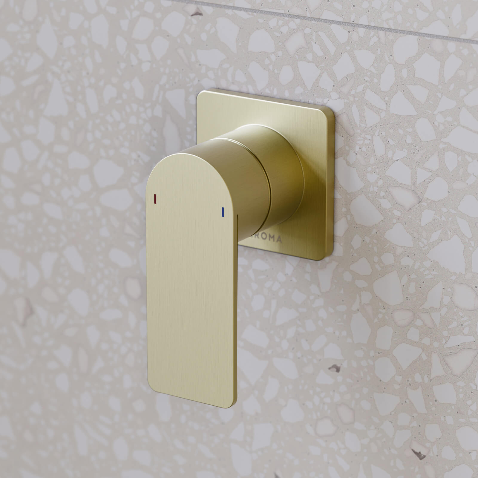 Caroma Urbane II square wall mixer in brushed brass on a terrazzo bathroom wall