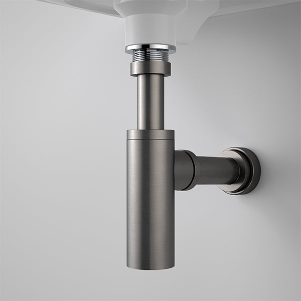Caroma 40mm bottle trap in gunmetal finish, exposed under wall-hung basin