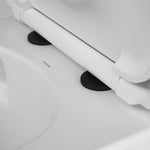 Caroma toilet seat hinge caps in matte black fitted to a white toilet seat, close-up detail view