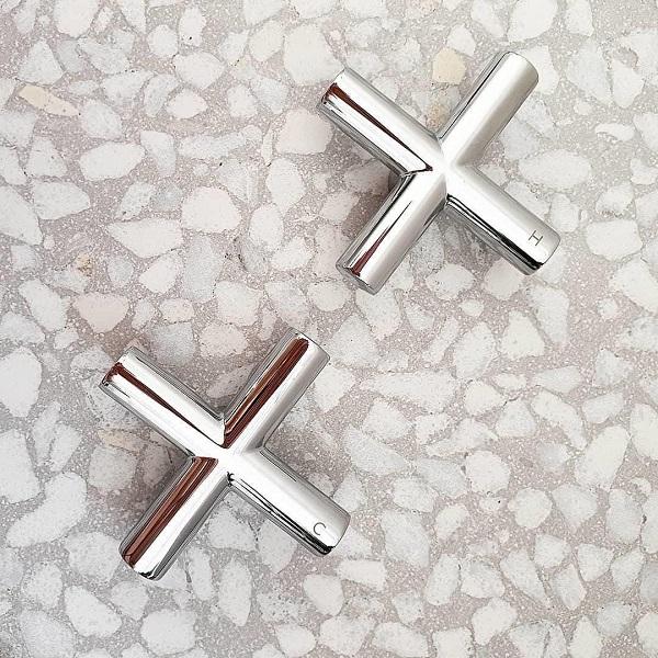 Clark Cross chrome wall top tap handles, shown as a pair on a stone surface