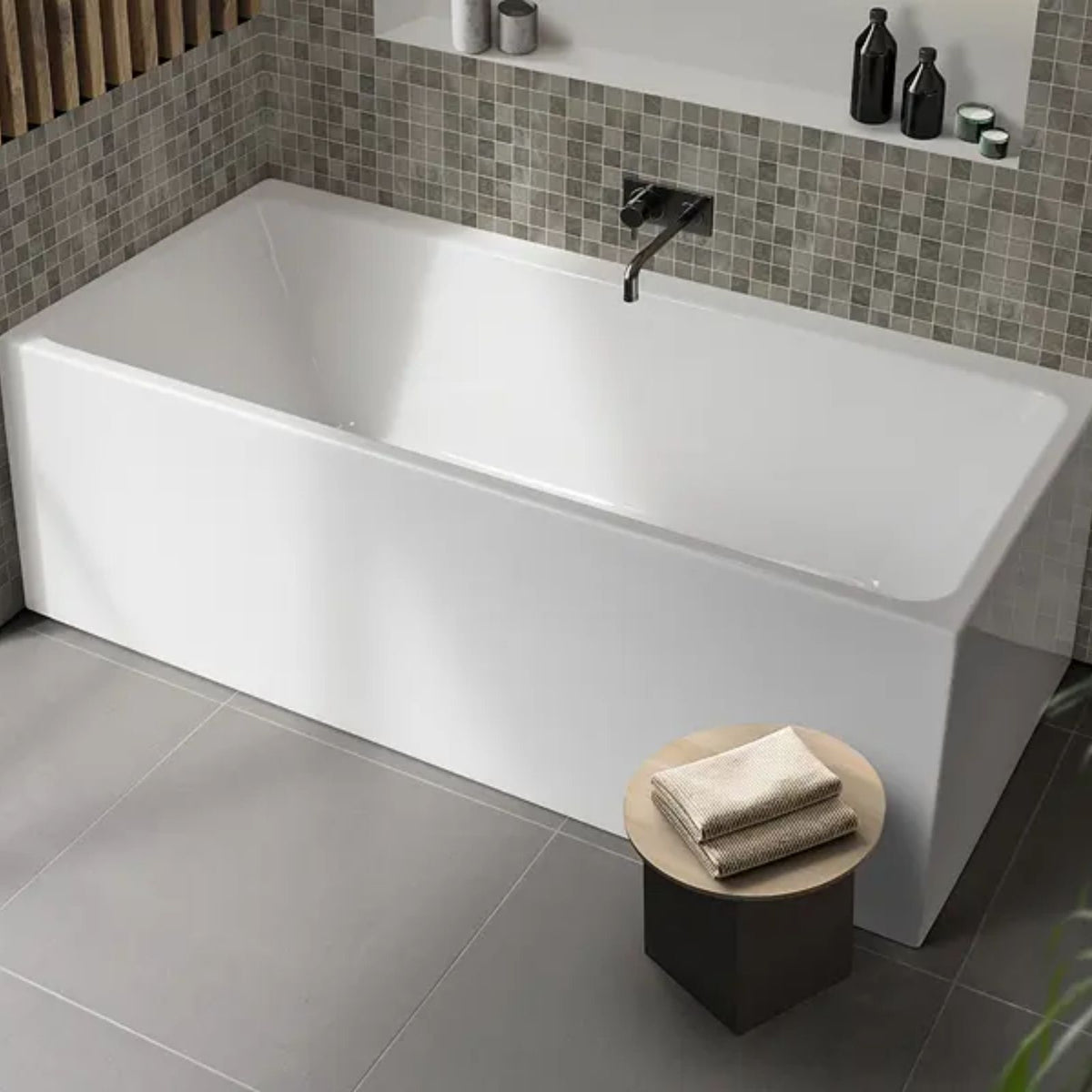 Decina Bianco white back-to-wall freestanding bath in a modern tiled bathroom, rectangular with black wall mixer tap