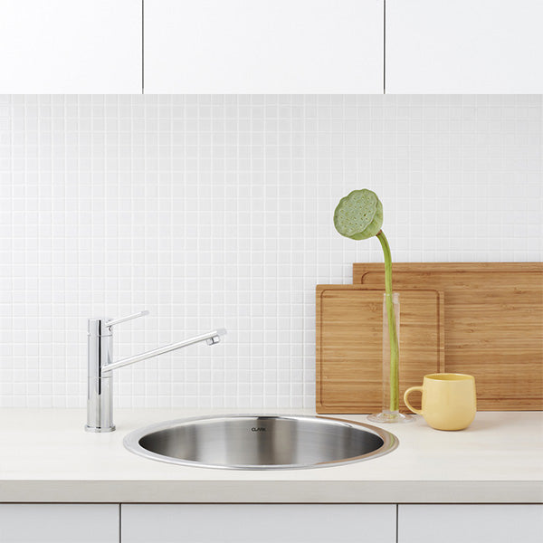 Dorf Villa chrome sink mixer with swivel outlet, shown installed beside a round stainless steel sink in a kitchen setting