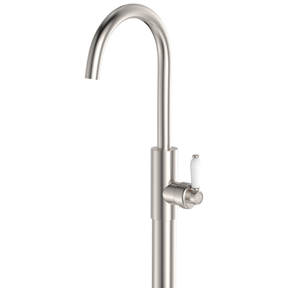 Fienza Eleanor floor mounted bath mixer in brushed nickel with curved swivel spout and white ceramic lever handle
