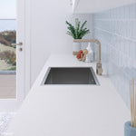 Fienza Hana stainless steel laundry sink in white benchtop, topmount or undermount single bowl with overflow, angled view