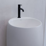 Fienza Kaya basin mixer in matte black, shown installed on a white round basin