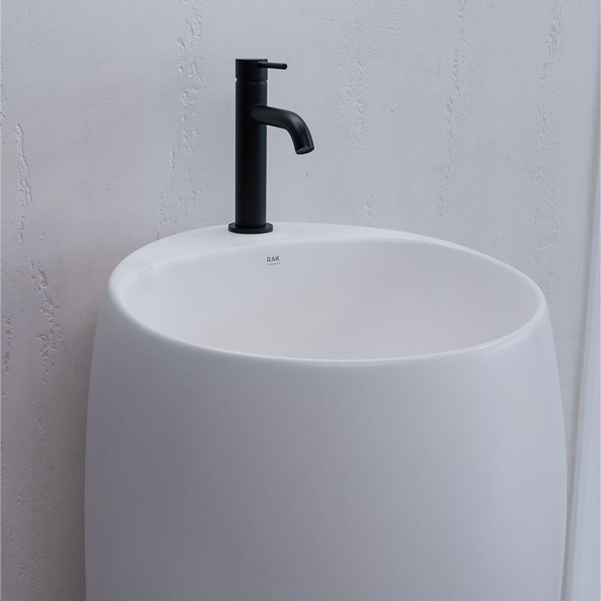 Fienza Kaya basin mixer in matte black, shown installed on a white round basin
