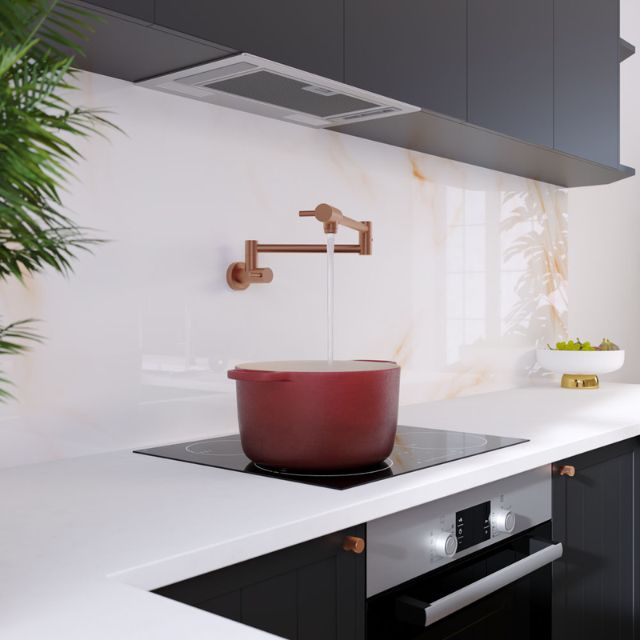 Fienza Kaya brushed copper pot filler wall mixer over cooktop, wall mounted in a modern kitchen, filling a red stockpot