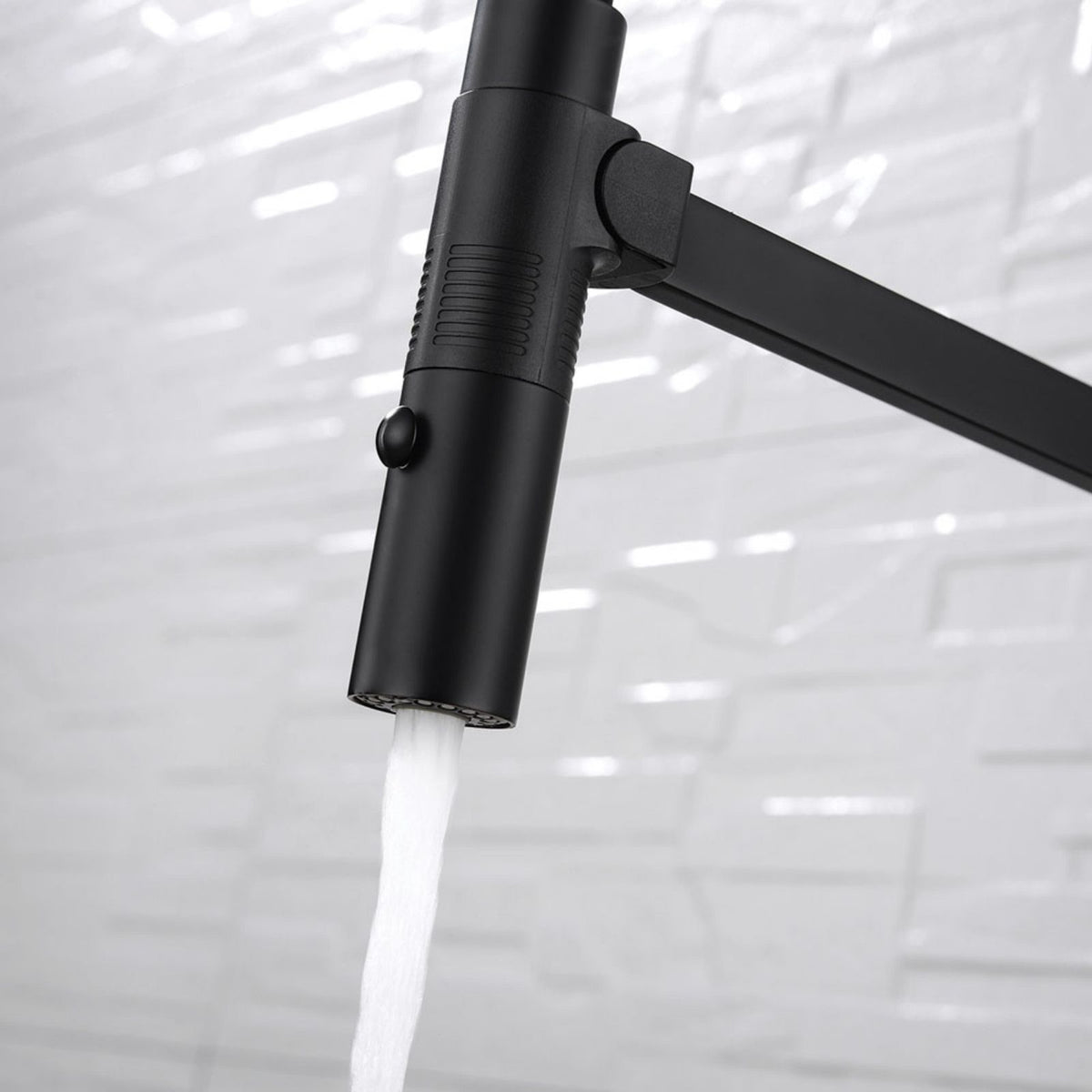 Fienza Kaya pull down sink mixer in matte black, close-up of the spray head with water flowing against a tiled kitchen background