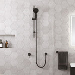 Fienza Kaya matte black rail shower with round hand shower, mounted in a tiled bathroom wall