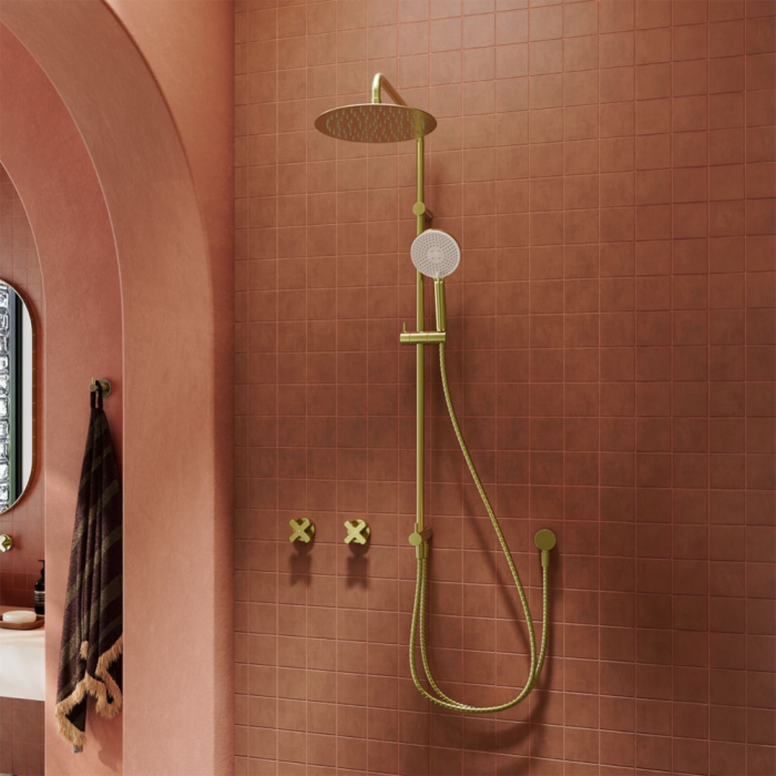 Fienza Kaya retrofit twin shower in urban brass, with round overhead rose and handheld rail in a pink tiled bathroom
