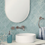 Fienza Kaya brushed nickel wall-mounted basin/bath tap set with round spout and handles over a white vessel basin