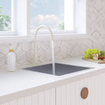 Fienza Kaya gloss warm white gooseneck sink mixer in a kitchen bench, side view over an undermount sink
