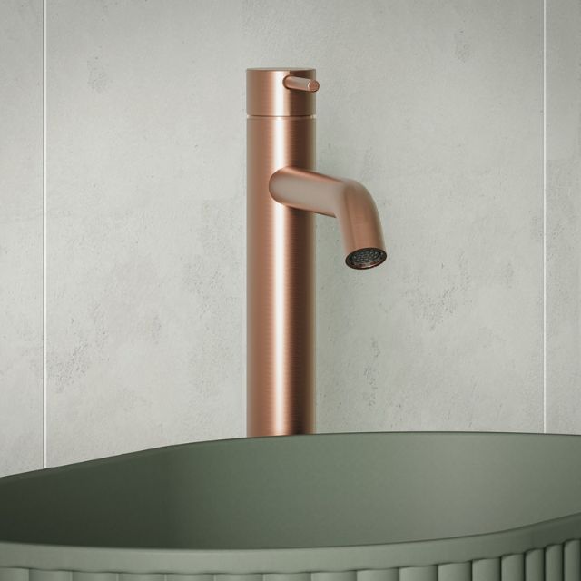 Fienza Kaya tall basin mixer in brushed copper, mounted above a matte green vessel basin