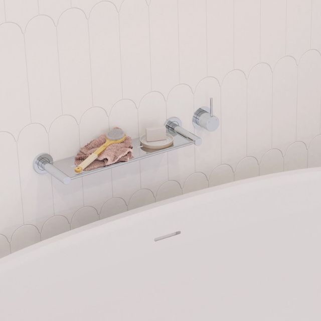 Fienza Kaya Up chrome wall mixer with small round plate, shown beside a bath in a tiled bathroom wall