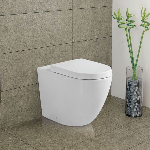 Fienza Koko wall-faced toilet suite in gloss white, floor-mounted with rounded back-to-wall design in a tiled bathroom corner