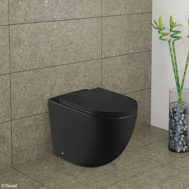 Fienza Koko wall-faced toilet suite in matte black, shown in a bathroom with tiled walls and floor.