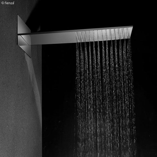 Fienza Komo chrome wall mounted overhead sheet shower with wide rectangular water flow in a dark bathroom setting