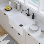 Fienza Olivia medium white butler sink with flat front, installed in a bright kitchen with black tapware and countertop accessories