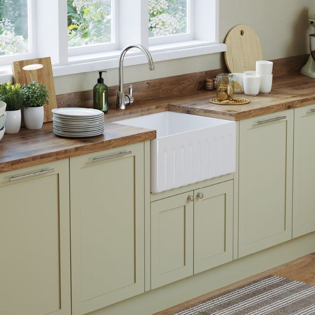 Fienza Olivia small white butler sink with fluted front in a kitchen bench, shown under a chrome tap