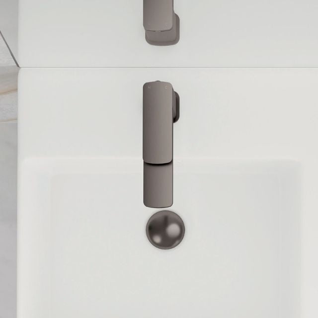Fienza Tono basin mixer in gun metal, hob mounted above a white basin, shown front on with round waste outlet visible