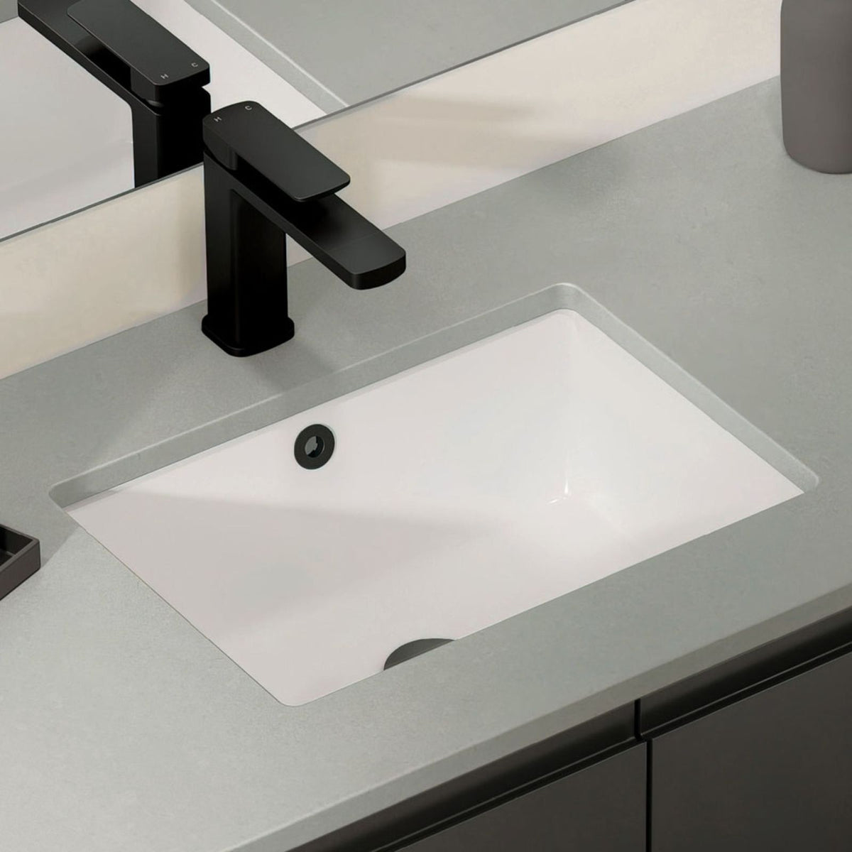 Fienza Tono matte black basin mixer over a white basin, showing the square hob-mounted tap on a grey vanity top.