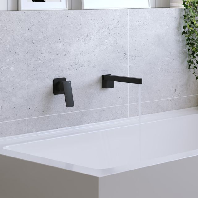 Fienza Tono matte black swivel bath outlet, wall-mounted over a bathtub, with matching black bath mixer on a tiled wall
